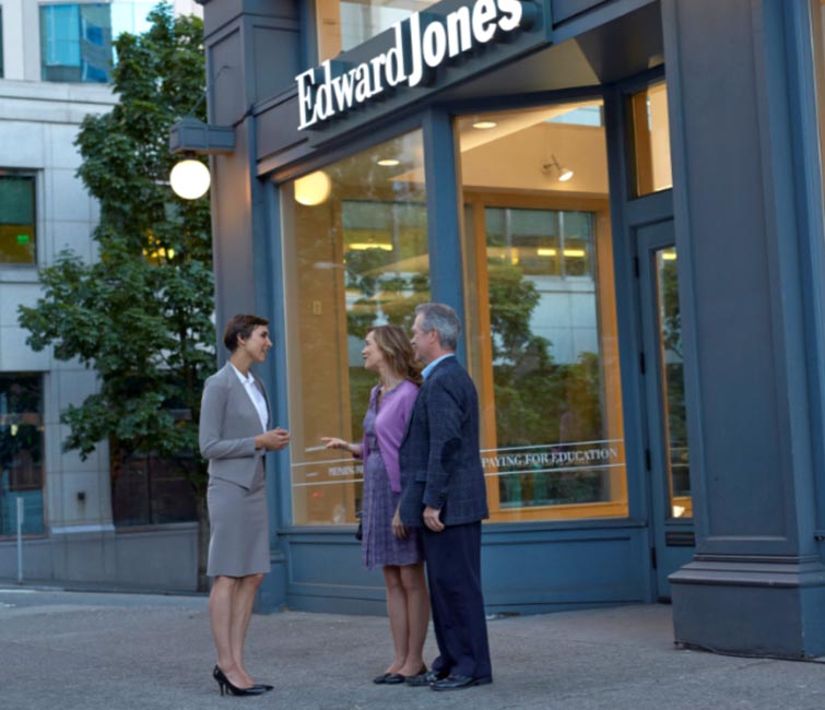 Un représentant en services financiers et un couple, à l’extérieur d’un bureau d’Edward Jones.