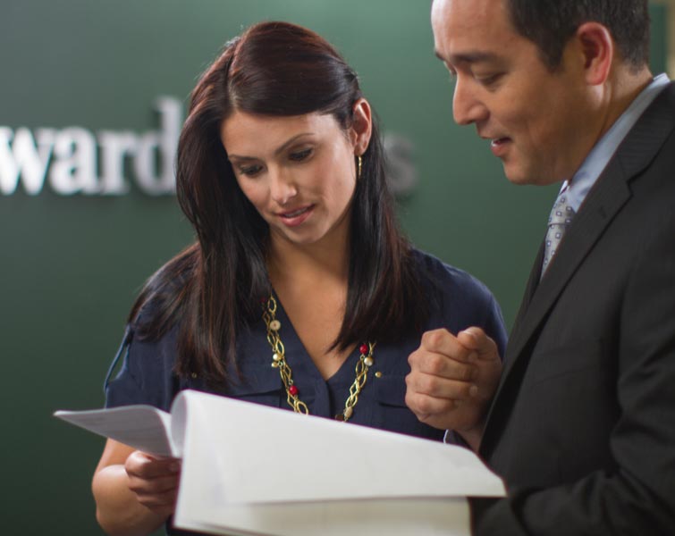 Un représentant en services financiers et un client examinent des documents.