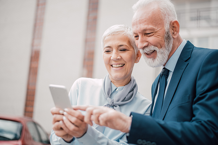 Happy senior couple looking at mobile phone