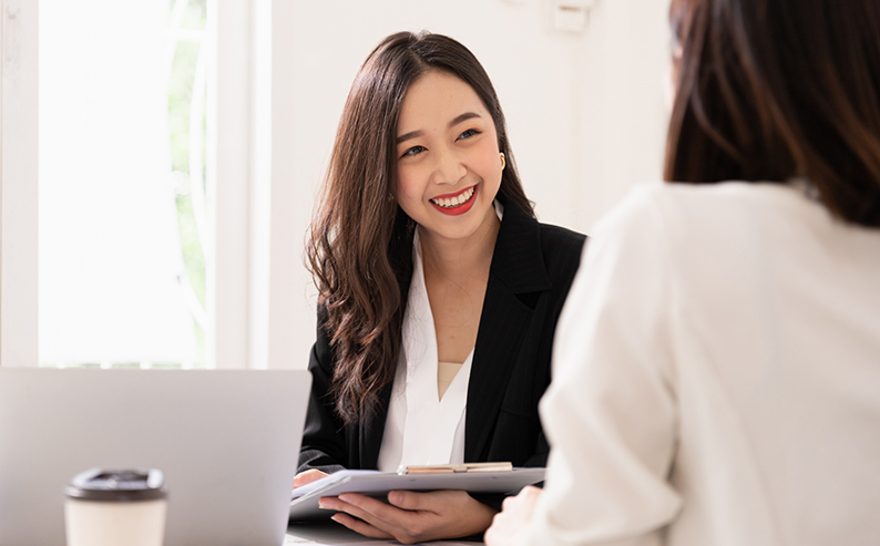 A young attractive asian woman is interviewing for a job. Her interviewers are diverse. Human resources manager conducting job interview with applicants in office Young Asian woman interviewing