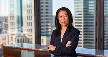 Business woman standing confidently in front of metro business window