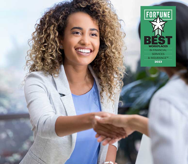 Woman shaking with a another woman with 2023 Best Workplaces in Financial Services & Insurance logo