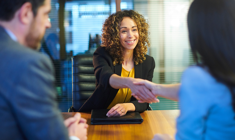 Business woman shaking hand with two clients.