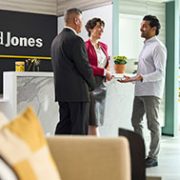 Women sitting and have discussion with a small group standing in the background talking in an Edward Jones office.