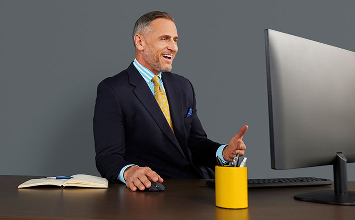 Business man at desk facing computer screen