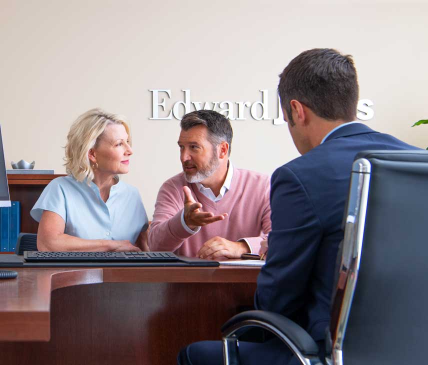 A couple having a discussion with a professional man in Edward Jones office.