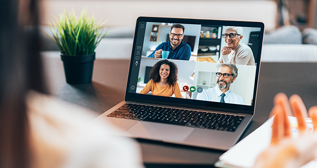 Over the shoulder shot of person viewing an online meeting on laptop screen.