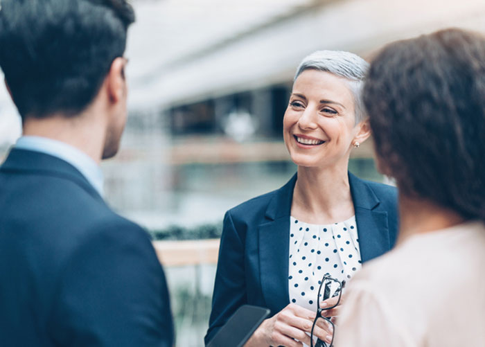 a woman talking to a man and woman.