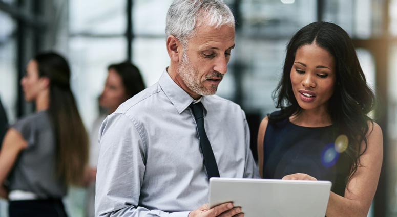 Male and female colleagues reviewing paper report.